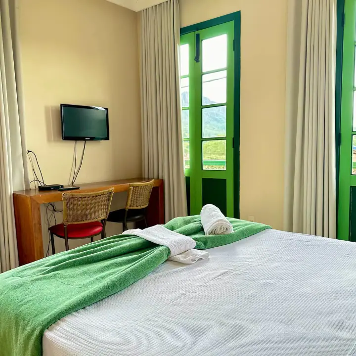 Habitación con ropa de cama blanca y marcos verdes